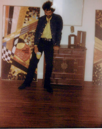 Hogan Ellis standing between two paintings during the Kingdom of Forgetting photo session