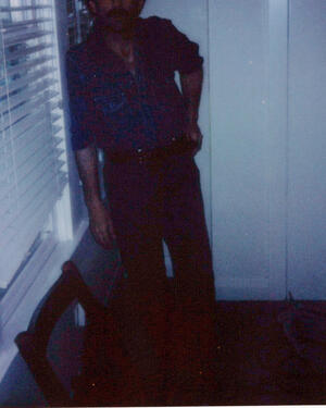 Hogan Ellis in blue light beside a window